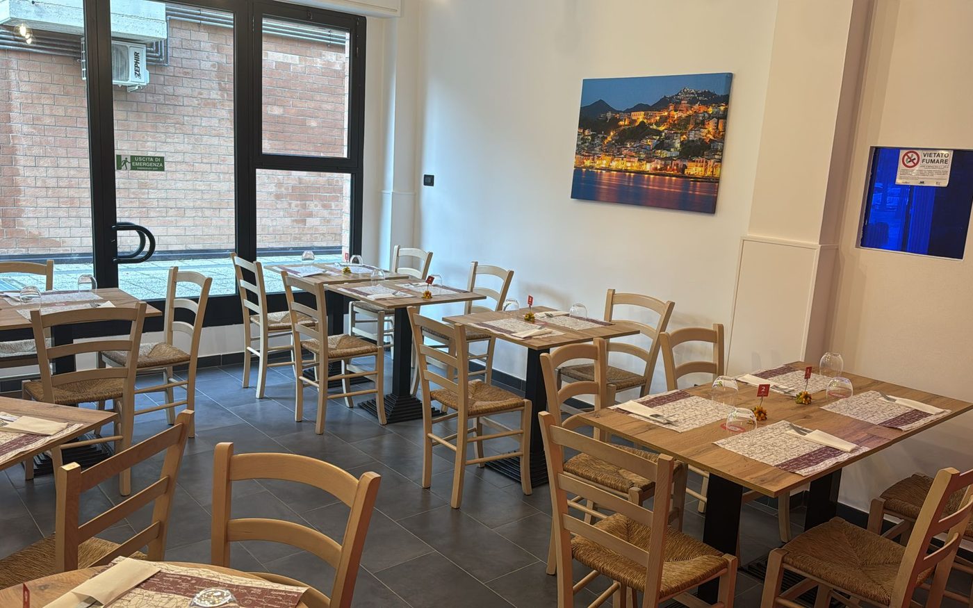 La sala con i tavoli in legno e le sedie impagliate
